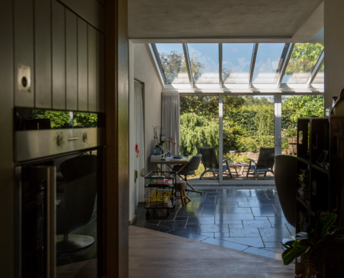 Een doorkijkje vanuit de keuken naar de woonkamer met serre aanbouw