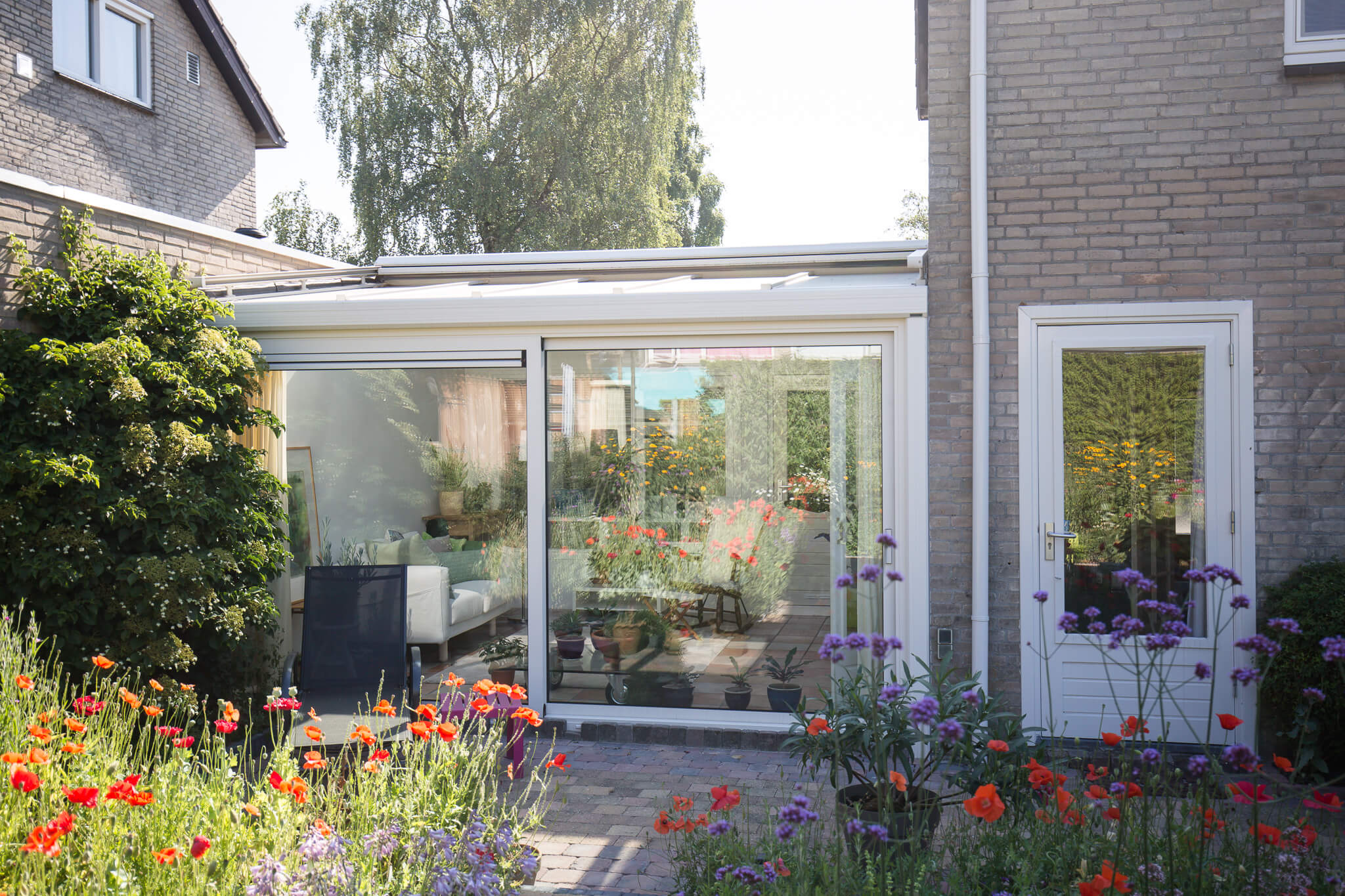 Uitbouw serre met veel daglicht en een prachtig uitzicht op de kleurrijke tuin